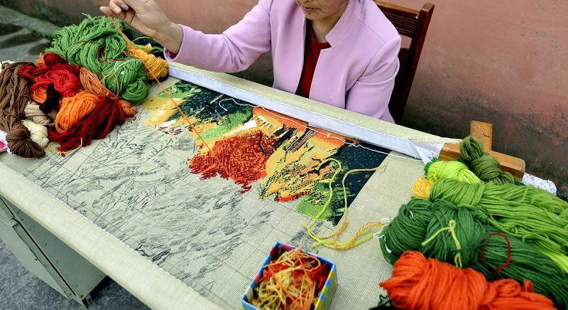 老城厢的傍晚，母亲专注绒绣的背影浸在汗水里