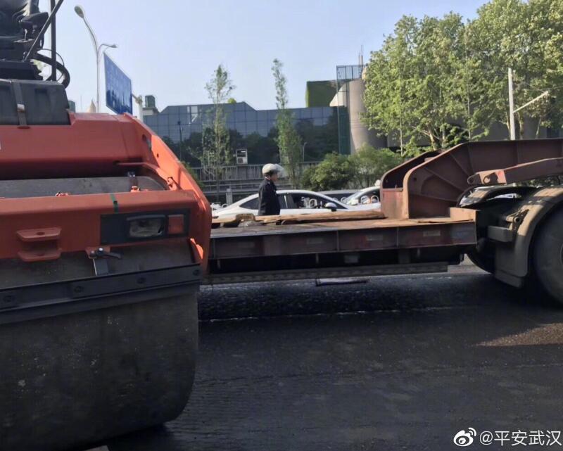 早上轧路机掉下平板运输车，致武珞路交通不畅，刚刚轧路机已被吊起